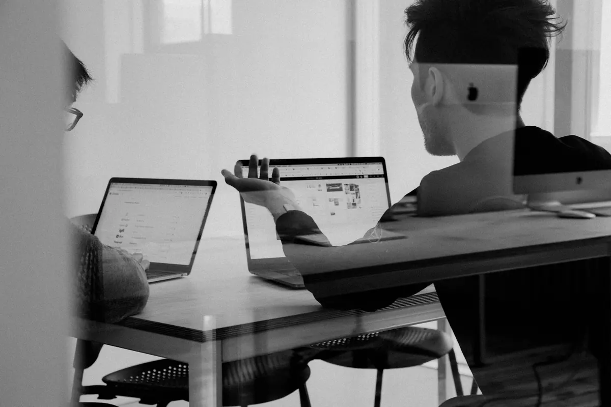 Two people in a focused one-on-one conversation at a work table